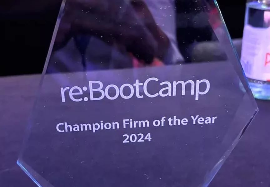 Picture of a glass award wth re:BootCamp Champion Firm of the Year 2024 engraved on, sat on a table.